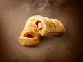Pieczeni hot dog z Lidla, posypany sezamem, z widocznym parującym wnętrzem. Zastanawiasz się, ile kcal ma hot dog z Lidla?
