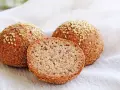 Proste keto bułki z sezamem, jedna przekrojona, ukazująca puszyste wnętrze. Idealne na dietę ketogeniczną.
