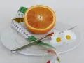 Pomarańcza na talerzu z miarką krawiecką i kwiatami symbolizuje zdrową dietę odchudzającą.