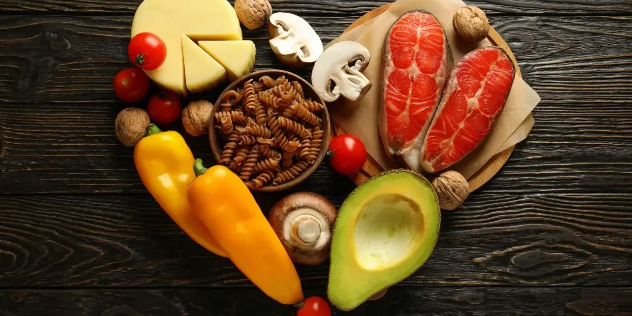 Serce z produktów: łosoś, awokado, ser, papryka, pomidory, grzyby, orzechy, makaron. Czy dieta keto a cholesterol to dobry wybór?