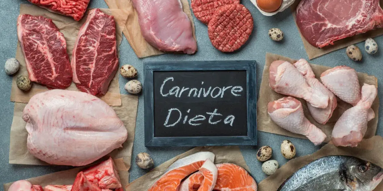 Różnorodne mięsa i ryby, jajka, kości. Tabliczka z napisem "Carnivore Dieta" sugeruje menu dla mięsożerców.