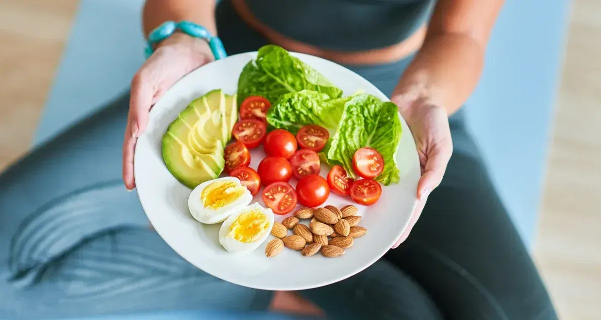 Talerz z awokado, pomidorkami, jajkiem i migdałami – idealny posiłek dla osób stosujących dietę imitującą post.