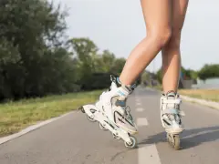 Nogi w rolkach na ścieżce rowerowej. Wspaniałe efekty jazdy na rolkach w letni dzień.