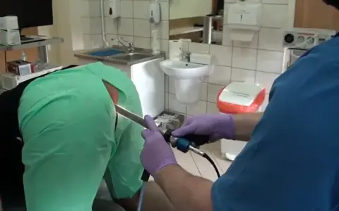Lekarz w rękawiczkach wykonuje badanie jelit za pomocą endoskopu.