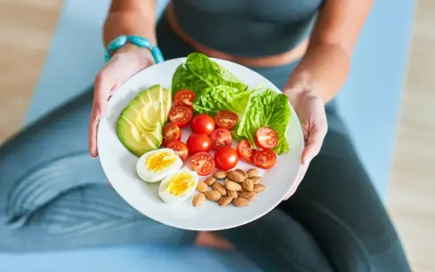 Talerz z awokado, pomidorkami, jajkiem i migdałami – idealny posiłek dla osób stosujących dietę imitującą post.
