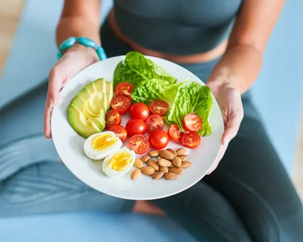 Talerz z awokado, pomidorkami, jajkiem i migdałami – idealny posiłek dla osób stosujących dietę imitującą post.