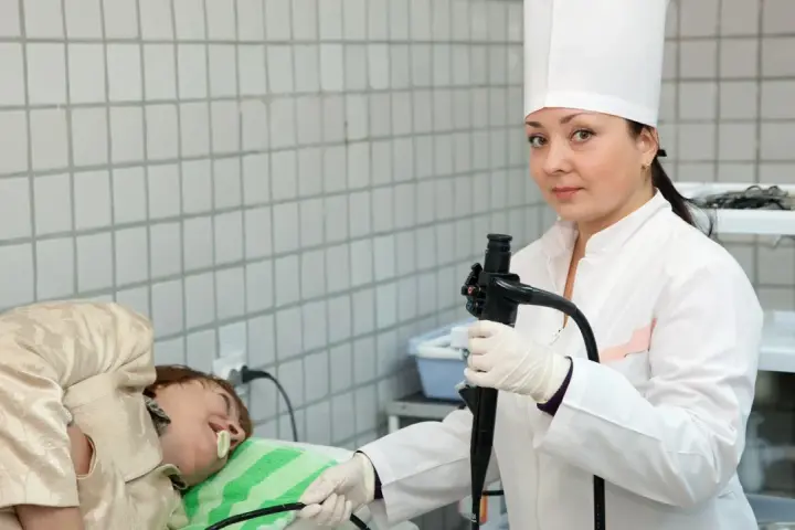 Lekarka przygotowuje pacjenta do gastroskopii. Przed badaniem ważne jest, co można jeść dzień przed gastroskopią – zazwyczaj lekkostrawne posiłki.